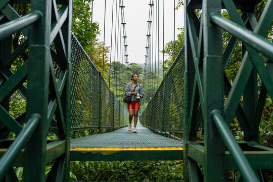 Professional photographer exiting a suspension bridge in the forest