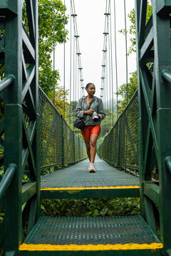 Female nature photographer finishing a hanging bridge trail