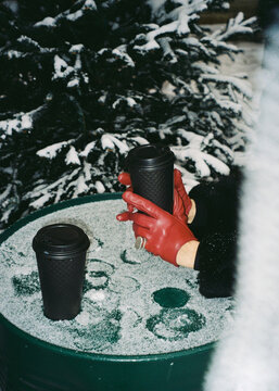 Anonymous woman hand in gloves holding a hot tea outside 