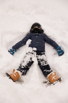 Boy making snow angel
