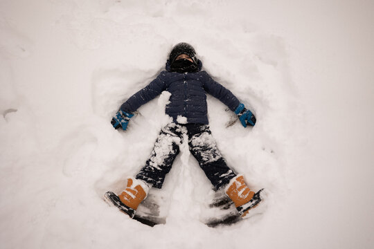 Boy making snow angel