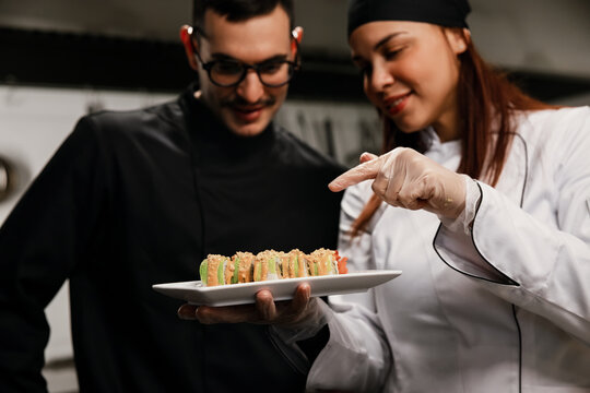 Chefs Present Plate Of Sushi In Professional Kitchen