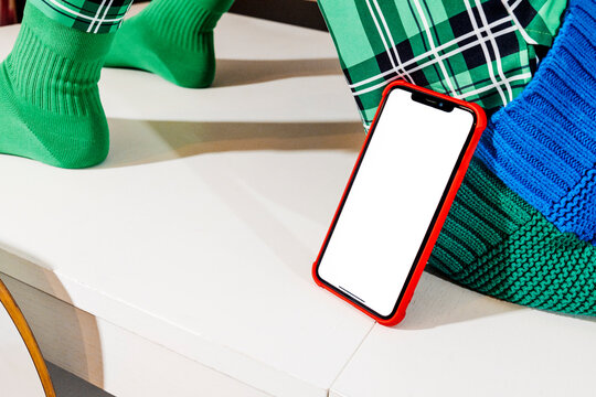 a phone rests on a table beneath a seated man