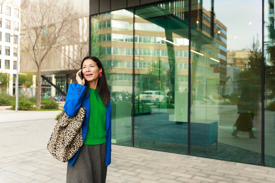 Woman Talking on Phone Outside a Building in a City