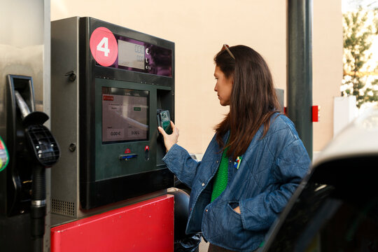 Woman Uses Gas Station Payment Machine in the Daytime