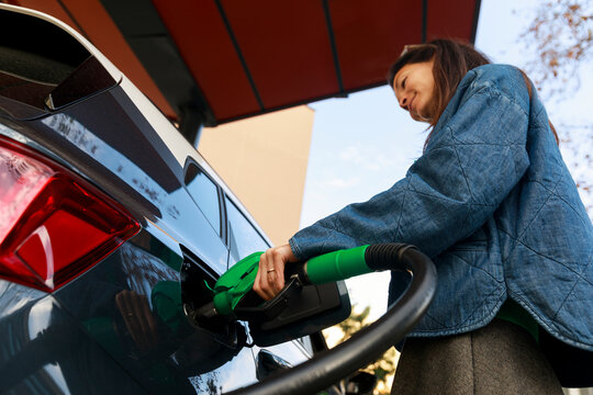 Woman Fuels Vehicle at Gas Station