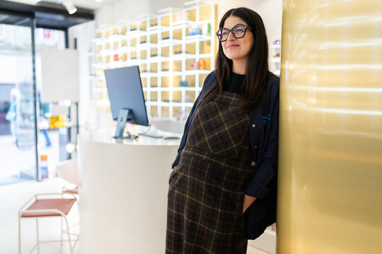 Pregnant optometrist working in modern optical shop
