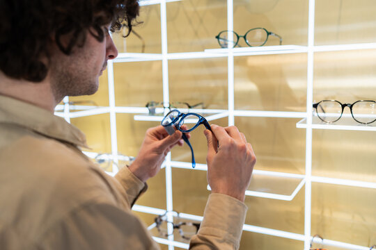 Man choosing new eyewear frames in optical shop