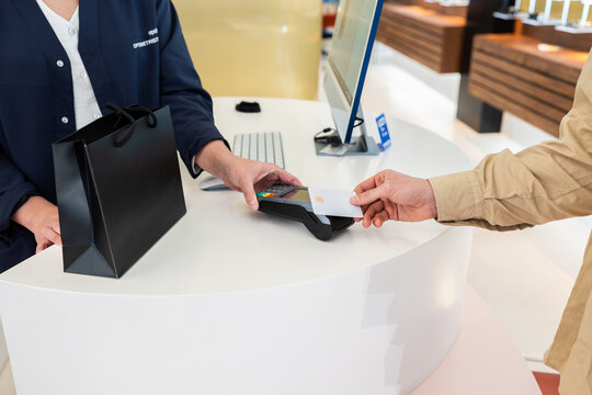 Customer paying with credit card at optical shop counter