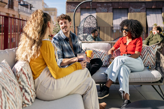 Diverse friends enjoying drinks at rooftop party