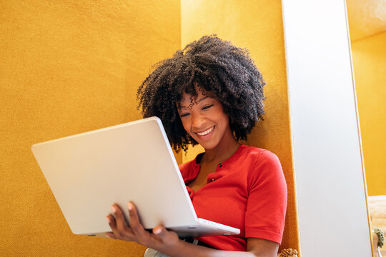 Happy black woman working remotely using laptop