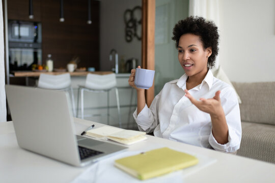 African American woman freelancer with mug during virtual meeting