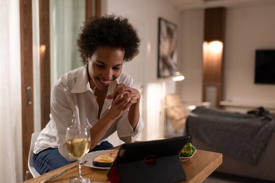 Happy black woman having online date during dinner