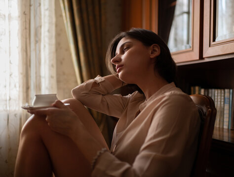 Young female resting with cup of hot beverage