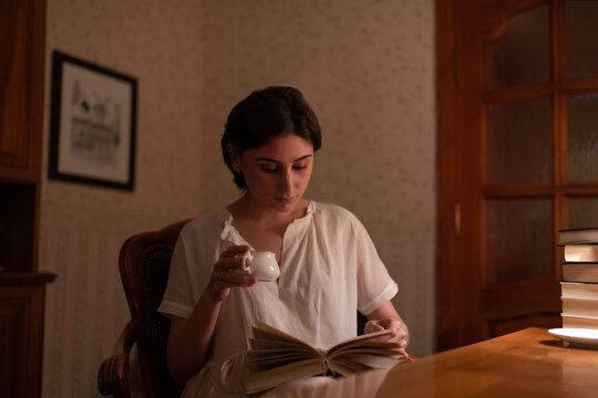 Young female with cup reading book