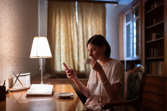 Female reader using tablet and enjoying hot drink