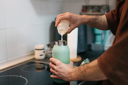 Parent preparing milk formula for baby at home