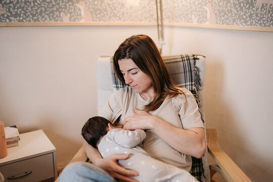 Parent breastfeeding baby creating loving bonding moment