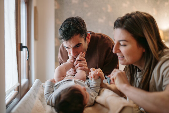 Parents bonding with newborn baby at home changing station
