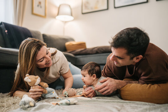 Parents playing with baby on floor at home