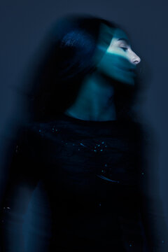 Model poses in dim light with blue tones at night