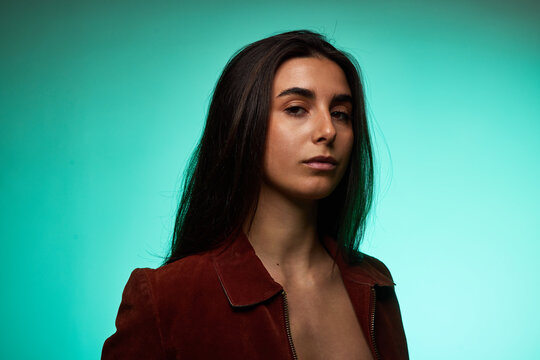 Model poses with hair down in front of a green background