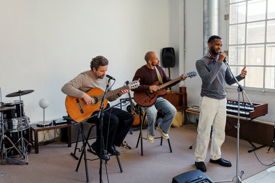 Musicians rehearsing in a studio playing instruments