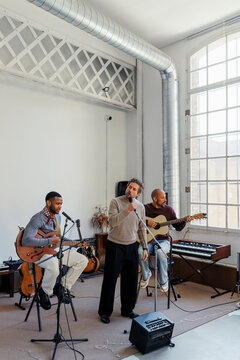 Group of musicians performing music in studio