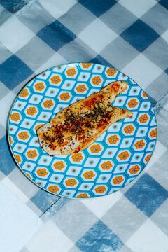 a grilled chicken breast fillet on a patterned plate