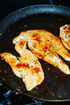 chicken breast fillets searing on a frying pan