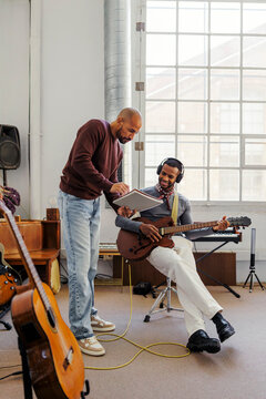 Musicians collaborating while composing music in studio