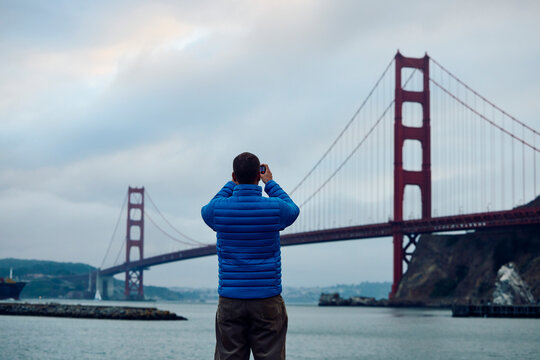 Man takes photos of the Golden Gate Bridge.