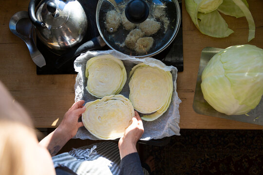 Woman preparing raw cabbage leaves for cooking