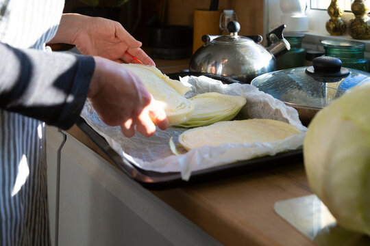 Woman preparing cabbage steaks for healthy cooking