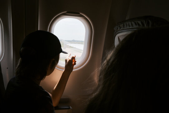traveling boy looking out of airplane window