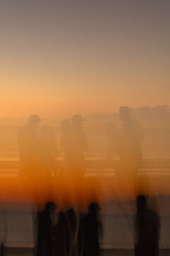 Abstract vertical composition of friends at sunset on the beach