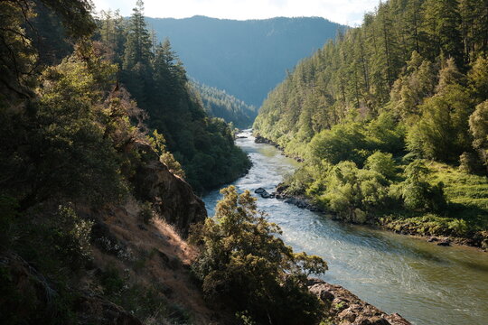 River Flowing Through Green Hills in the Afternoon Sun