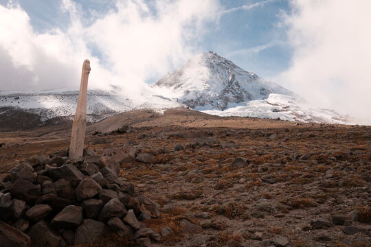 Mountain Peak With Clouds and Rock Formation in the Foreground