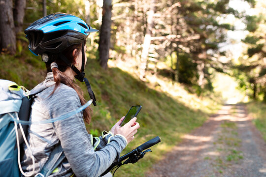 Cyclist Checking Phone GPS Navigation on Forest Trail