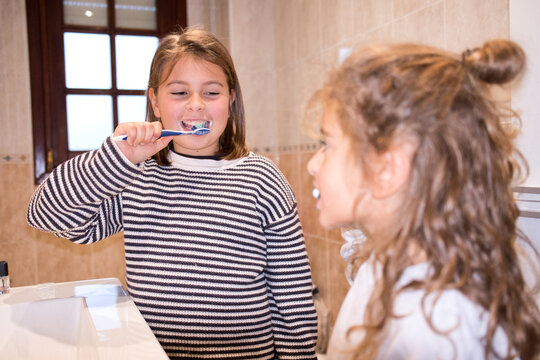 Children brushing teeth together practicing daily hygiene routine