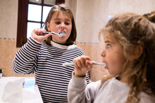 Children brushing teeth together for daily hygiene routine