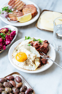 Plate with fried egg and pulled pork surrounded by sides