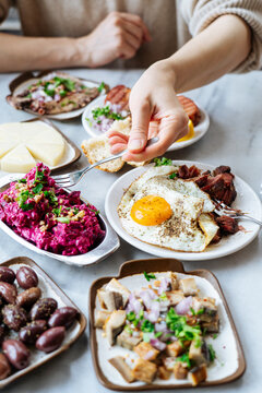 Person reaching for beet salad with assorted Mediterranean food