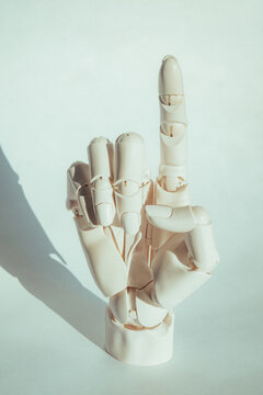 Model hand signals one with finger raised in indoor setting