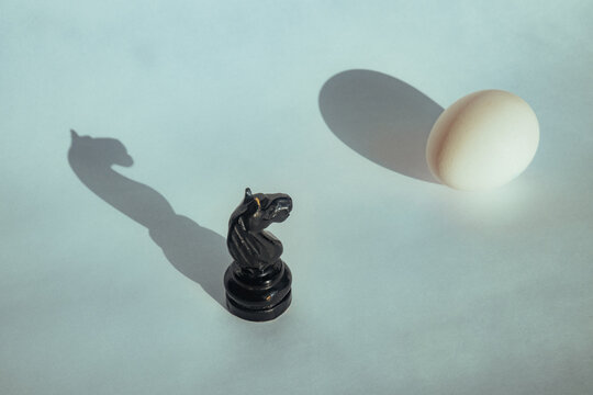 Chess piece and egg on a plain background in soft light