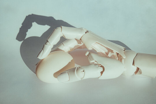 Robot hand holds an egg on a light background