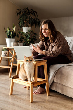 A woman working at home with her cat.