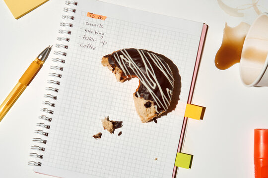 Coffee Break With To-Do List and a Half-Eaten Doughnut on Table 