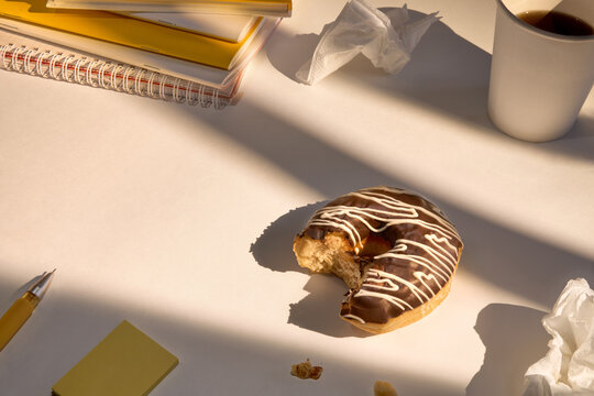 Donut on a Table With Coffee and Notebooks During Afternoon Study Time