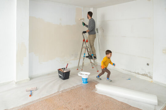 Father and son painting home during renovation project